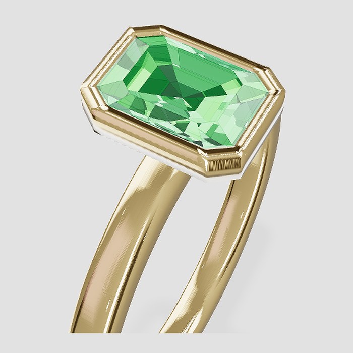 An emerald-cut green stone in a gold bezel