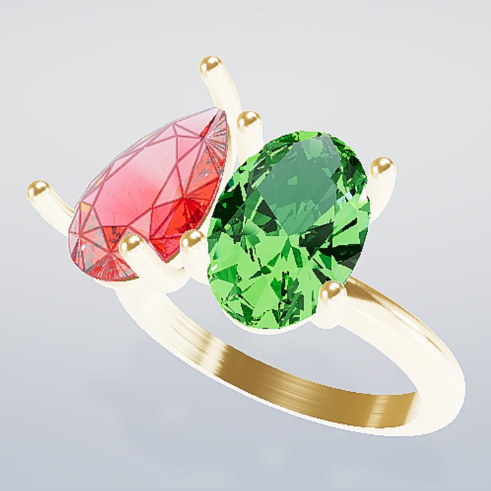 A pear diamond and an oval green stone on a gold toi-et-moi ring